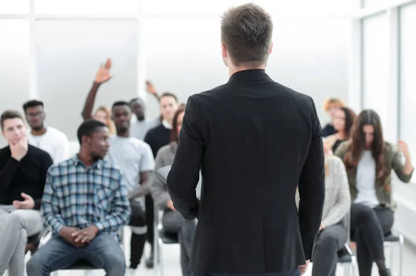 Spreker en een groep uiteenlopende jonge luisteraars in een vergaderzaal — Stockfoto