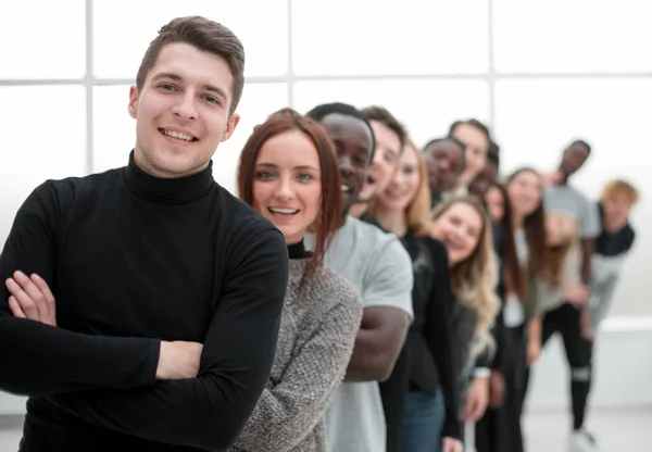 Mladý muž stojící před skupinou mladých lidí — Stock fotografie