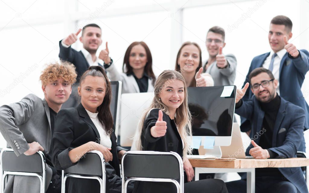 large team of young employees giving a thumbs up