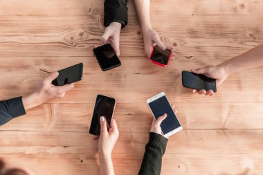 Üst düzey iş adamlarının elinde cep telefonları var.