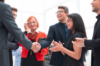 Meslektaşlar ofiste toplandıktan sonra tokalaşırlar