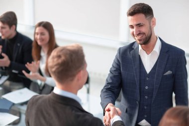 Toplantı sırasında masa başında oturan iş adamları...