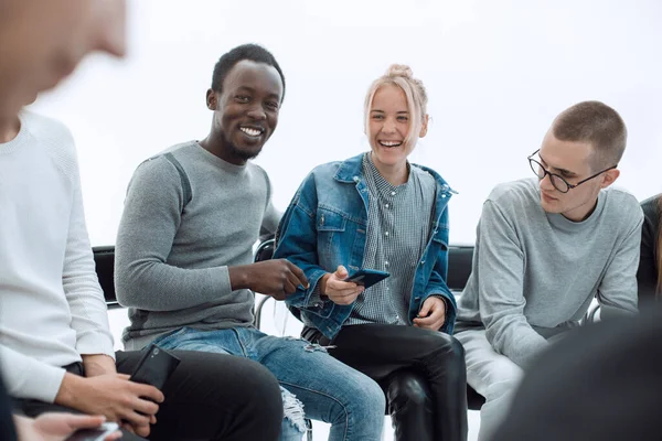 De cerca. jóvenes que leen información sobre sus teléfonos inteligentes — Foto de Stock