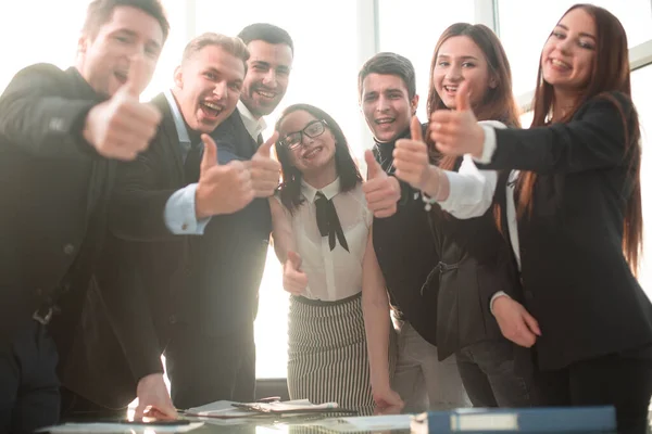 Succesvolle zakenmensen met duimen omhoog en lachend — Stockfoto