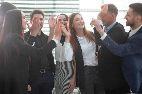 Vrolijk business team doet high five tijdens het zitten in het kantoor — Stockfoto
