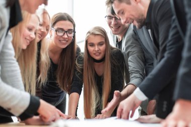 Kapat. Çalışma belgelerini tartışmaya hevesli bir grup çalışan.