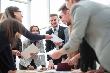 Kapat. İş ekibi çalışma belgelerini hevesle tartışıyor