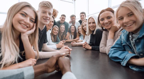 Fecha. um grande grupo de amigos sentados a uma mesa longa — Fotografia de Stock