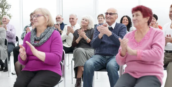 Skupina seniorů tleská v konferenční místnosti — Stock fotografie