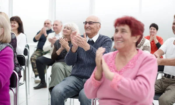 Un gruppo di anziani applaude nella sala conferenze — Foto Stock