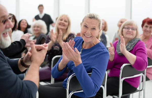 Een groep ouderen zit in een cirkel te klappen. — Stockfoto