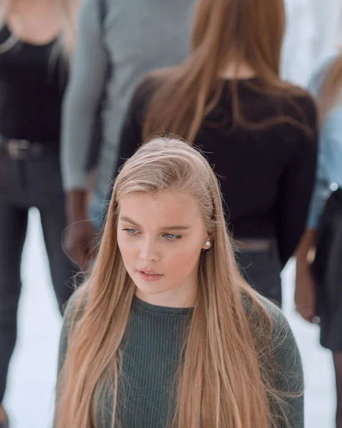 Ernste Frau steht vor lässiger Gruppe junger Leute — Stockfoto