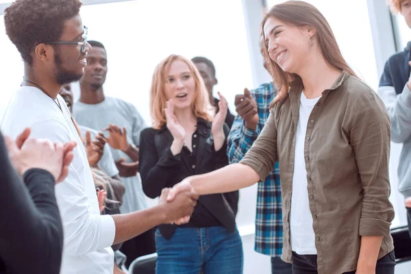 Grupo de jóvenes felices felicitando a su colega — Foto de Stock