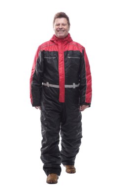 Kışın yalıtılmış tulumlu bir adam ileri doğru yürüyor.