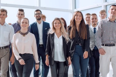 Genç iş adamları yeni bir ofiste birlikte yürüyorlar.