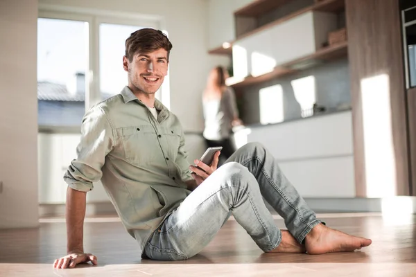 Jovem homem ler mensagens em seu smartphone — Fotografia de Stock