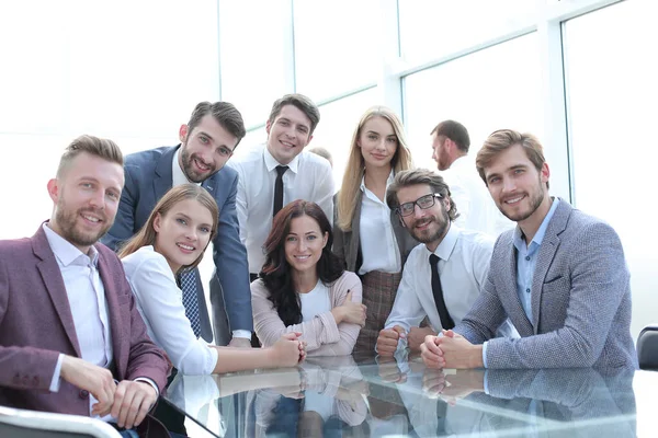 Equipo profesional de jóvenes empresarios sentados a la mesa. —  Fotos de Stock