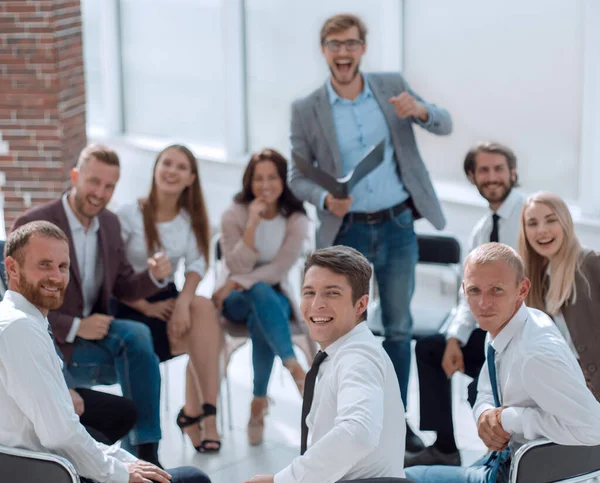 Trainer und eine Gruppe junger Geschäftsleute sitzen in einem Konfetti — Stockfoto