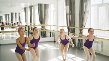 Atlama ve mutlu bir şekilde ışık Studio bale barre ve ayna ile bağırarak bale dansçıları başlayan genç kızların ağır çekim. Çocukluk ve mutluluk kavramı.