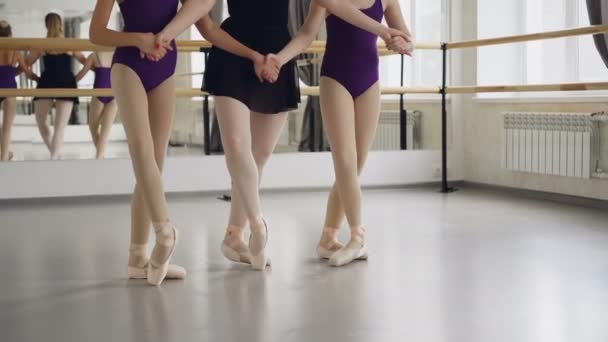 Tiro bajo de piernas femeninas en zapatillas de ballet estudiantes y profesor bailando de puntillas haciendo pasos en el suelo en el salón de baile. Coreografía, ballet clásico, arte y concepto infantil . — Vídeos de Stock