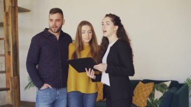 Neşeli house Ajan satış koşulları tartışıyor ve kağıtları gösterilen alıcılar çok güzel genç bir çift için konuşuyor. İstemciler yeni apartment hakkında heyecanlıyız..