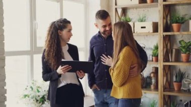 Genç aile yeni daire konut ajan için satın alma gayrimenkul hakkında sarılma ve duygusal eller konuşuyor. Ev taşıma ve mülkiyet kavramı satın alma.