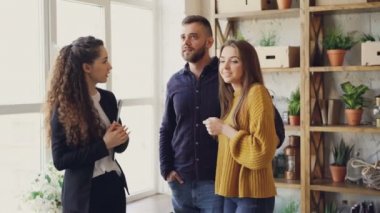 Kendine güvenen emlakçı etrafa, söz ve gülümseyen genç çiftin evine avantajları anlatıyor. Karı koca yeni konaklama hakkında heyecanlı mısın.