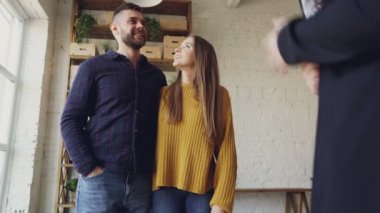 Onlar satın almak için gidiyoruz ev iç seyir ve gerçek emlakçı ile görüşmeden gençlerin düşük açılı atış. Mutlu çift konut alanı seviyor.