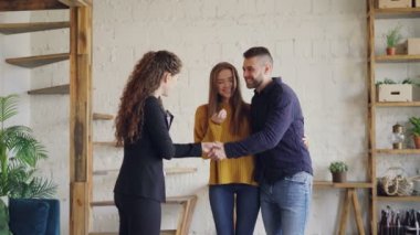 Emlak alıcılar anahtarları konut Aracısı'ndan sonra başarılı bir anlaşma elde, Öpüşme ve mutluluk ile ve kadın broker tokalaşırken.