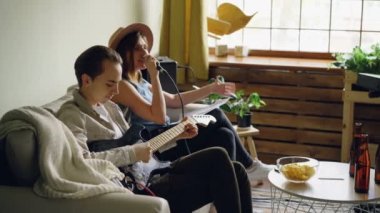 Neşeli genç insanlar müzik grubudur enstrüman gitar ve klavye oyun ve mikrofon şarkı güzel evde prova sırasında.