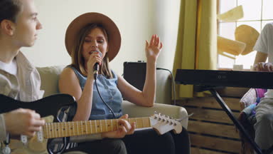Arkadaşlar müzik müzik müzik aletleri oynuyorsunuz ve şarkı, kadın şarkıcı şarkı sözleri unutma ve gülüyor. Dostluk, müzik ve eğlence kavramı.