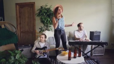 Güzel sarışın müzik grubu şarkı ve dans iken onu arkadaş gitarist ve keyboarder gitar ve klavye çalmaya ve gülümseyen sanatçısıdır.