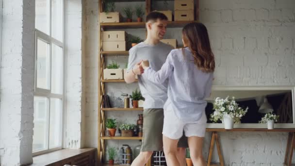 Adorabile coppia mista sta ballando sul letto in abiti casual, parlando e ridendo insieme godendo momenti felici di relazione romantica. Concetto di romanticismo e persone . — Video Stock