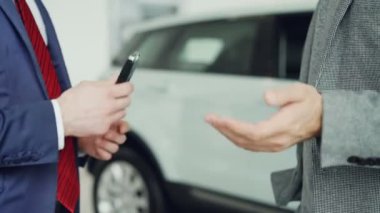 Satış Müdürü ile başarılı anlaşma sonra arabanın anahtarlarını almak ve el sallayarak erkek el atış kapatın. Alış ve satış arabalar, işadamları ve el sıkışması kavramı.