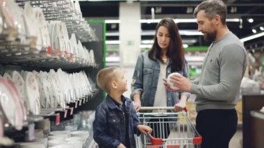 Genç aile mutfak eşyaları bölümü süpermarkette kase seçmektir, bunları karşılaştırarak ve konuşurken ürünler burada tutuyorlar, küçük çocuk ailesi yardımcı oluyor.