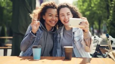 Arkadaşlar selfie tablo sonra izlerken fotoğraf ve gülen dokunaklı ekran Sokak kafede otururken smartphone ile alıyor. Dostluk ve fotoğraflar kavramı.