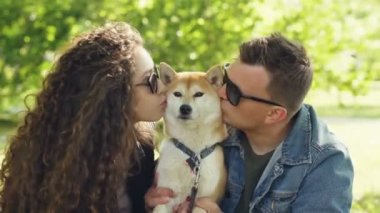 Güzel köpek shiba Inu sevgi dolu sahipleri hayvan öpüşme ve parkta birlikte dinlenme sırasında kafasına sevişme. Aşk, Evcil hayvan ve sağlıklı yaşam konsepti.