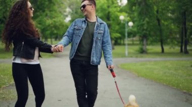 Ağır çekim neşeli çift köpek parkta yürüyüş ve birlikte iyi zevk eğleniyor, serbest zaman ve yaz şirketi. İlgili ipucu koşma mutlu hayvan.