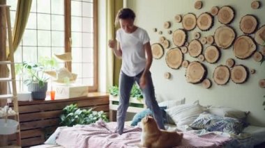 Oynak karışık yarış kız casual giyim eğlenceli sahip müzik, atlama ve onun güzel shiba süre yatak odasında dans Inu köpek yatağında dinleniyor.