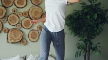 Ağır çekim müzik, yatağa dans ve evcil köpek istirahat ederken yatak odasında evde şarkı etkin Afrikalı-Amerikalı kadın. Eğlenceli ve hayvanlar kavramı.