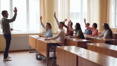 Gençler öğrenciler eller yükselterek ve sakallı ise öğretmenler sorulara cevap adam Profesör konuşma ve el hareketi. Dostane bir atmosferde, ışık Oda.