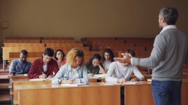 Duygusal öğretmen iken özenli öğrencilerin dinleme ve not alma yeni bilgileri açıklayan yetişkin öğrenciler için konuşuyor. Meslek, eğitim ve insan kavramı.