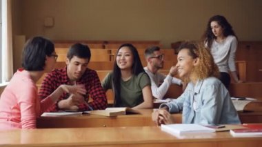 Dikkatsiz kızlar ve erkekler konuştuğunuz ve oturma masaları konferans salonunda gülüyorsun, mola sırasında rahatlatıcı öğrencilerdir. Konuşma, modern eğitim ve gençlik kavramı.