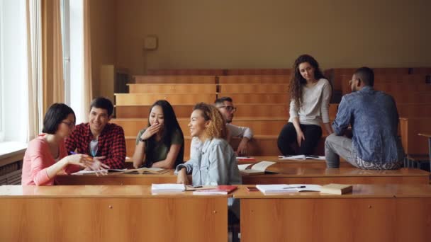 Los jóvenes están hablando y relajándose durante el descanso entre las conferencias universitarias, los estudiantes están disfrutando del descanso y la comunicación. Estilo de vida moderno y concepto educativo . — Vídeo de stock