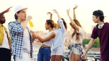 Genç insanlar dans ve erkek gülerek Dj yaz gününde çatı partisi ekipman ile çalışmaktadır. Eğlence, gençlik ve müzik konsepti.