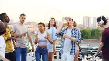Ekipman giyen kulaklık ile çalışma arkadaşlarının Dj karıştırma süre Modern gençlik çatı zevk müzik dans ediyor. Parti, kutlama ve eğlence kavramı.