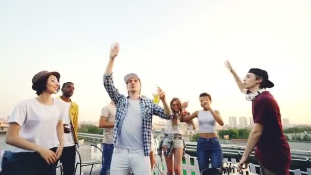 Aantrekkelijke studenten voor meisjes en jongens dansen op open-air party met professionele Dj werken met mengpaneel. Vrienden zijn frisdrank drinken en plezier. — Stockvideo