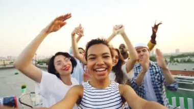 Bakış açısı shot çatı kameraya bakarak Afro-Amerikan kız dans ve sahip eğlenceli çok ırklı grup ile parti. Eğlence ve gençlik kavramı.