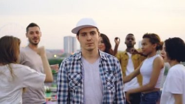 Çatı partisi sonra başlangıç dans, atlama ve having fun, kamera bakarak üzgün yakışıklı adam portresi. Eğlence, modern şehir ve insanlar kavramı.