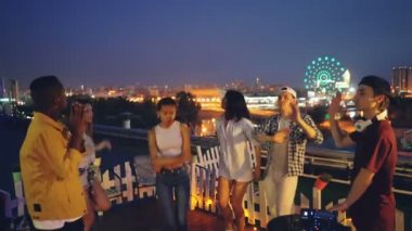Arkadaşlar çok ırklı grup gece ise Dj Ekipmanları ile çalışma o zaman eller alkışlar açık hava partisi çatı katında dans. Parti, kutlama ve eğlence kavramı.